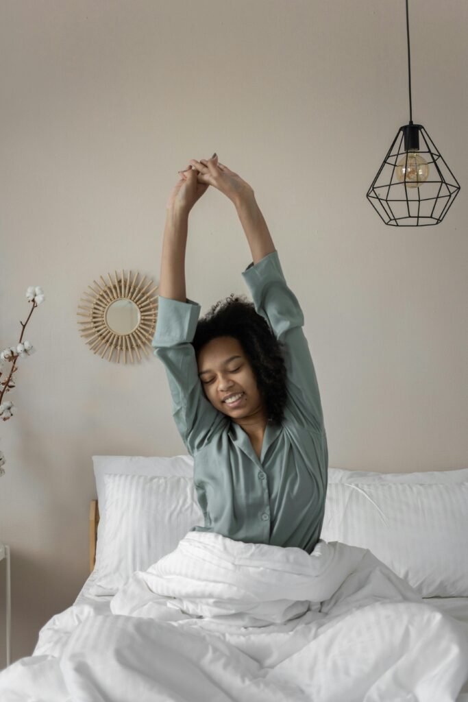 self care Sunday - a woman stretches in bed before standing up