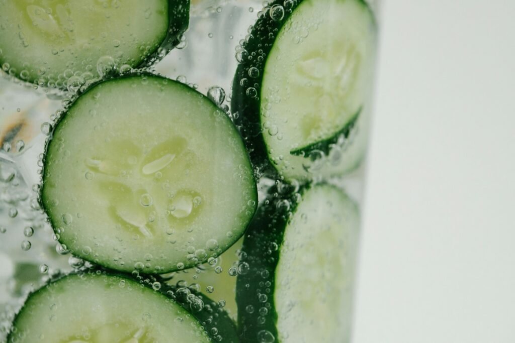 summer wellness tips - diy spa water in this image a glass of cucumber water