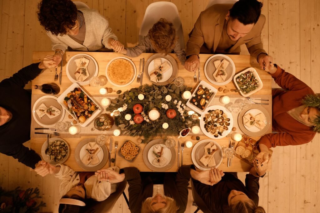 thankful quotes for november - aerial view of a dinner table surround by friends and family. They are seated around the table. Food and drinks are on the table.