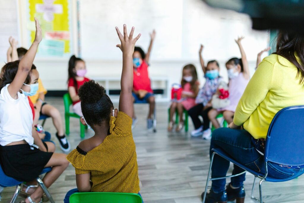 a teacher checks for student understanding in her classroom as students' hands are raised