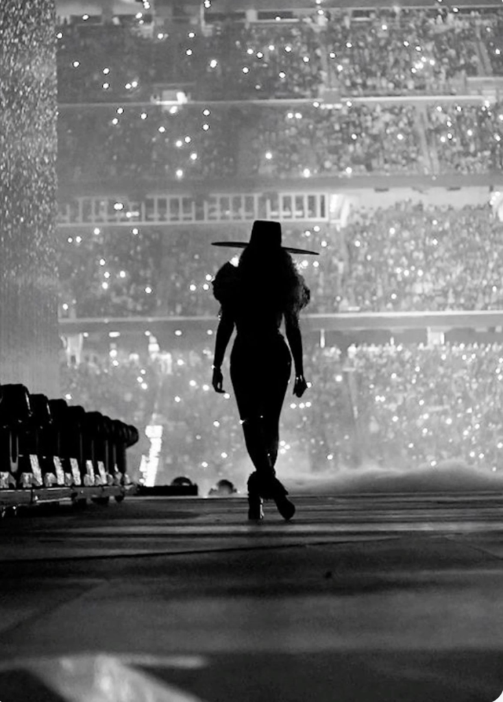 Silhouette of Beyonce on stage in front of a full crowd at her Renaissance World Tour.
