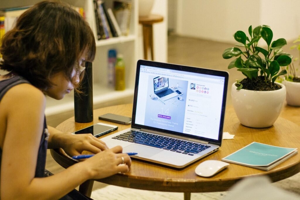 a woman sits engaged in online learning using her laptop