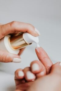 a woman pumps serum or lotion onto her index finger