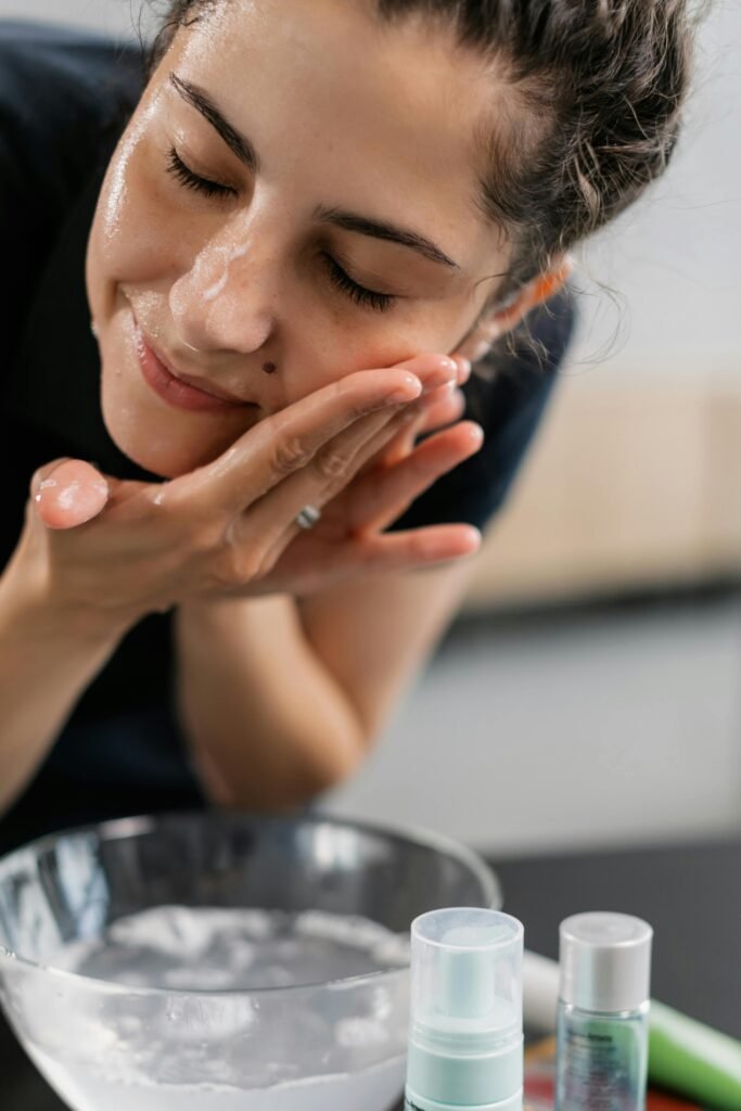 Double Cleansing: a woman washing her face with 2 types of cleansers