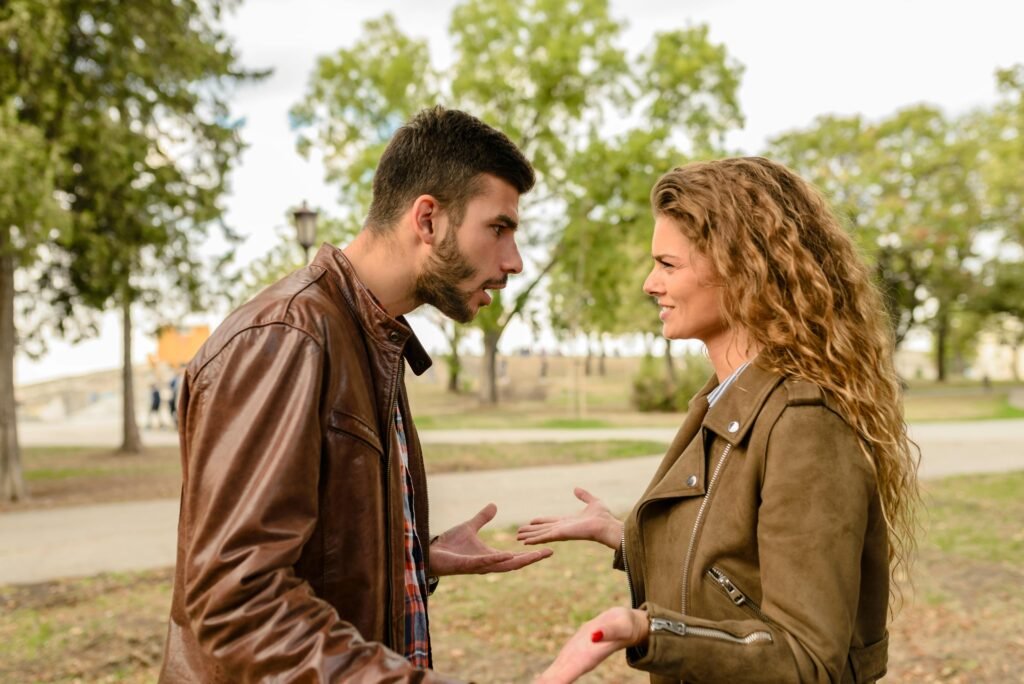 These 10 Things Make You the Perfect Partner for a Narcissist. A couple is arguing in a park. The male is very emotional while the female is not taking things seriously or is unbothered