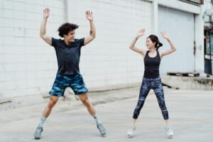 Morning Routine to Speed Up Metabolism: a man and woman are doing jumping jacks