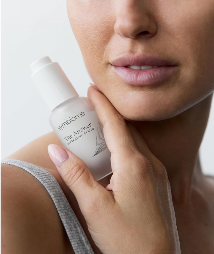 best stem cell serum for face - product image with the model holding the bottle close to her face. Her eyes are not shown in the pic