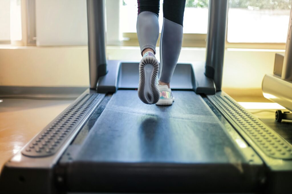 a faceless image of a person on a treadmill shown from the calves downward-walking or running