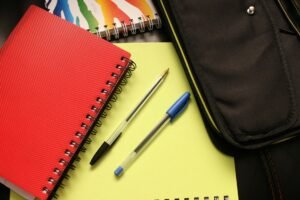 Amazon back to school savings - a pic of school supplies (2 pens, 2 notebooks, and a binder)