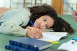 How to Overcome Procrastination for Students - a student puts her head down on her desk while studying