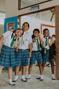 welcome back-to-school - a group of students in their school uniforms pose for the camera in their school's hallway