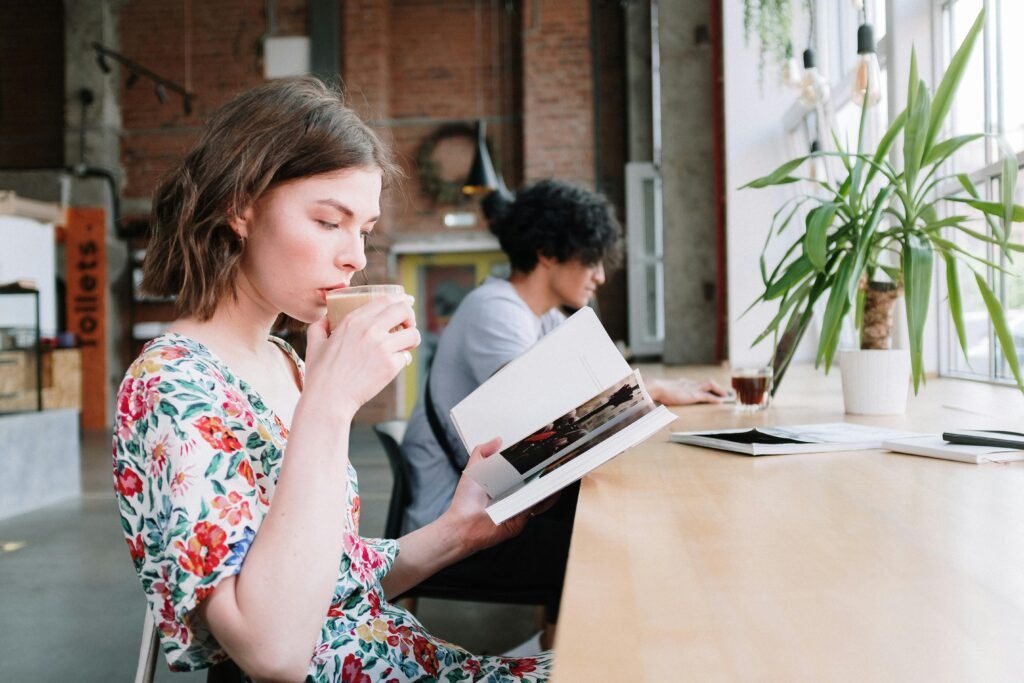 Non-Negotiables for Setting Boundaries - a woman sits in a coffee shop drinking coffee while reading a book