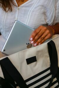best bags for teachers- an image of a woman putting a Macbook in her tote bag