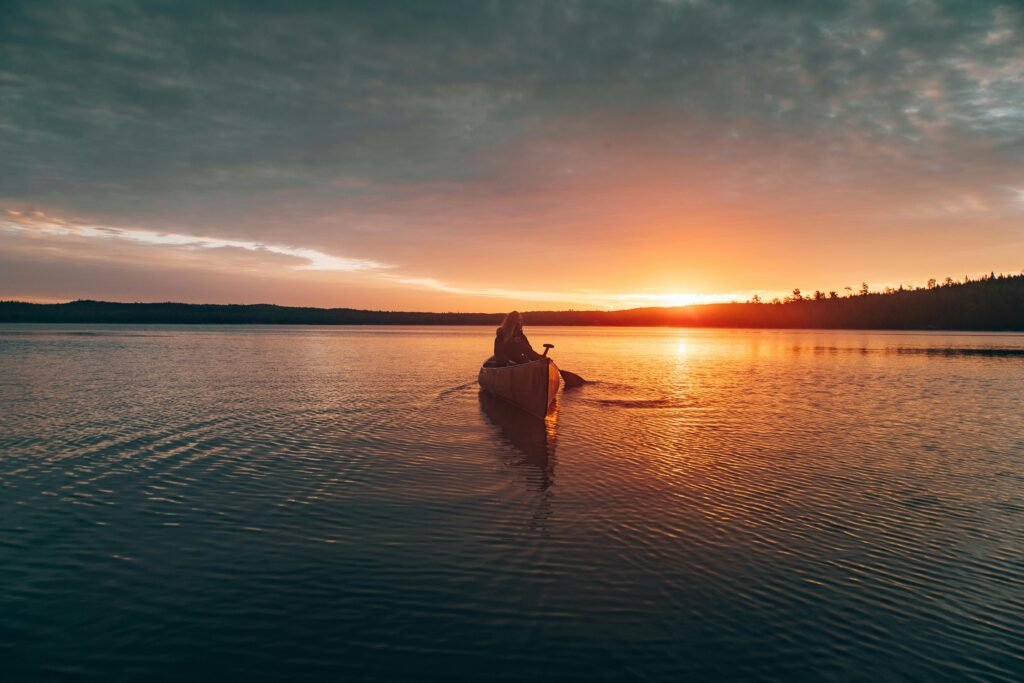 a kayak rests on a lake in the evening